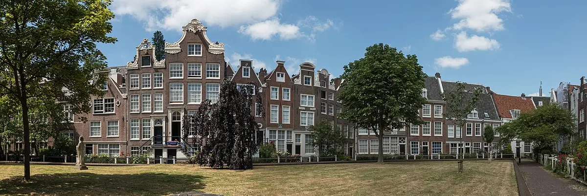 Old houses around the grassy courtyard of the Begijnhof in Amsterdam.