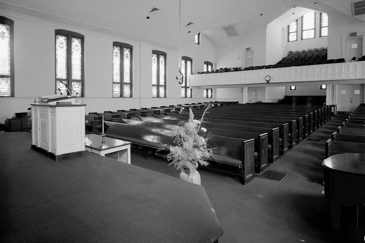 The sanctuary of Historic Ebenezer Baptist Church seen from the pulpit, with pews, arched windows and a balcony (black and white).