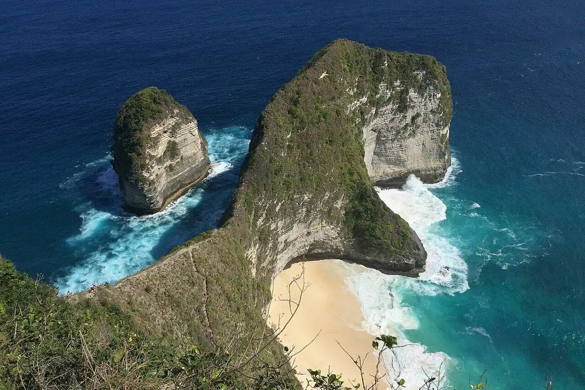 The dinosaur-shaped headland reaching into the sea above a white-sand cove.