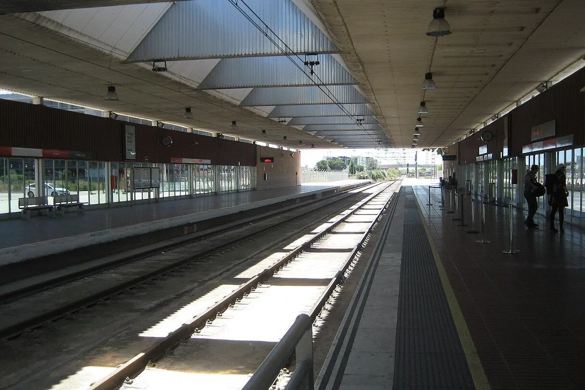 Tracks and platforms running straight under the roof of the Barcelona airport railway station.