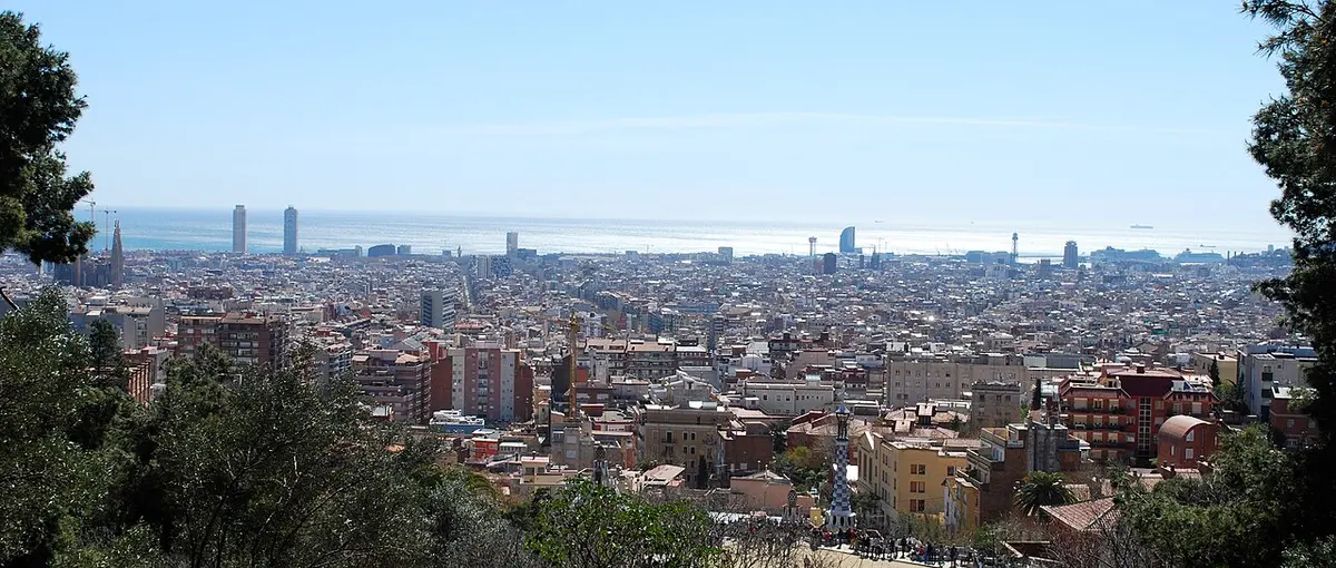 Barcelona's city spread out below a hillside, with the sea in the distance