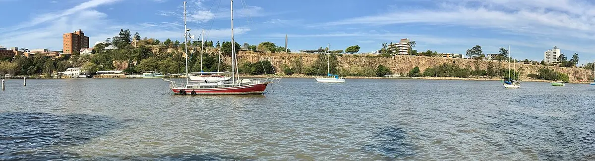 The steep rock face of Kangaroo Point Cliffs seen across the river