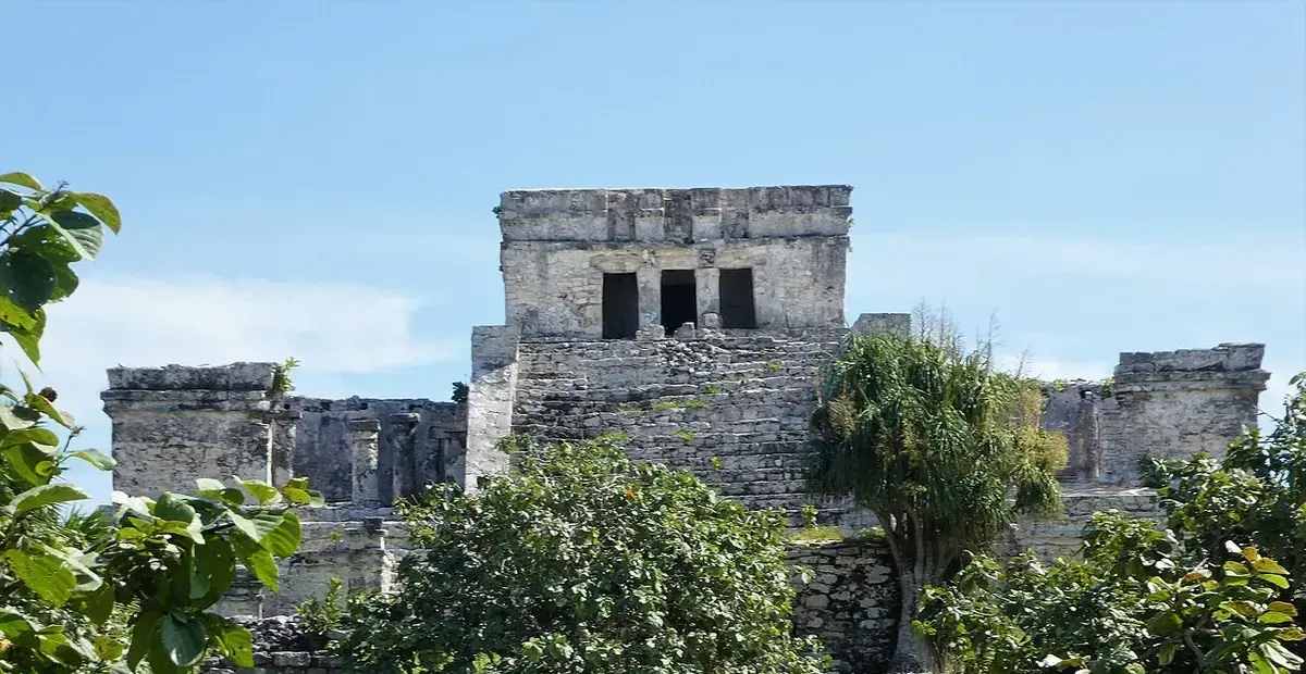 El Castillo, the main temple at the Tulum archaeological site, rising behind tropical greenery.