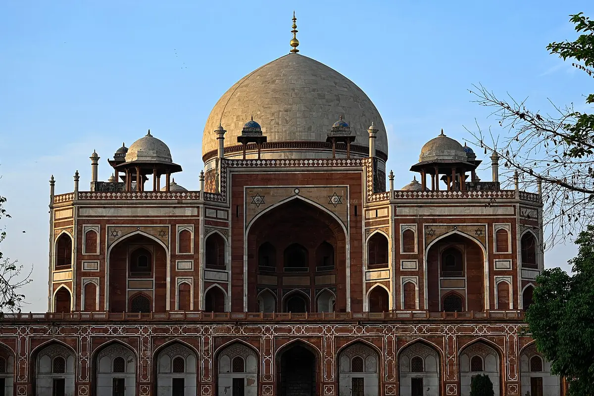 Front view of Humayun's Tomb in Delhi, its red sandstone and white marble dome under a clear blue sky.