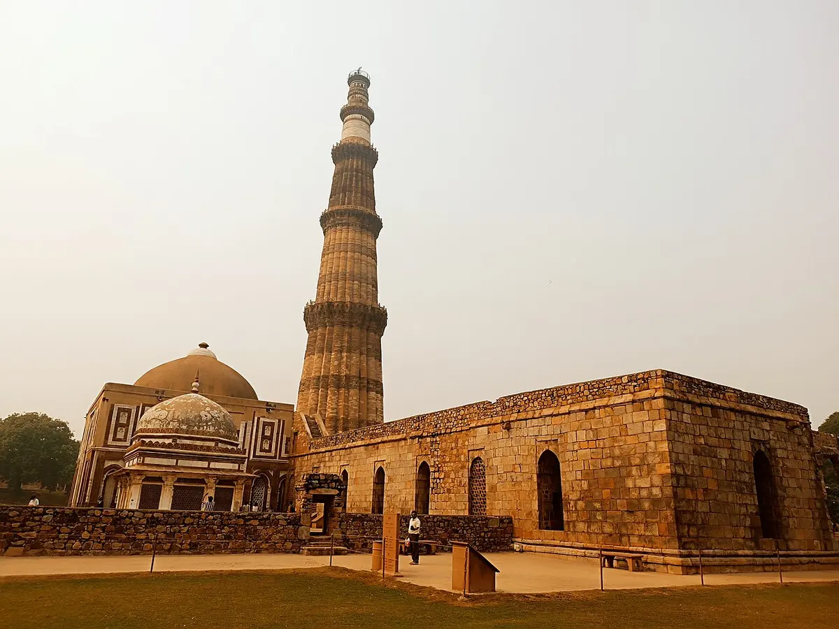 The red sandstone tower of Qutub Minar rising above the historic structures of the Qutb Complex, Delhi.