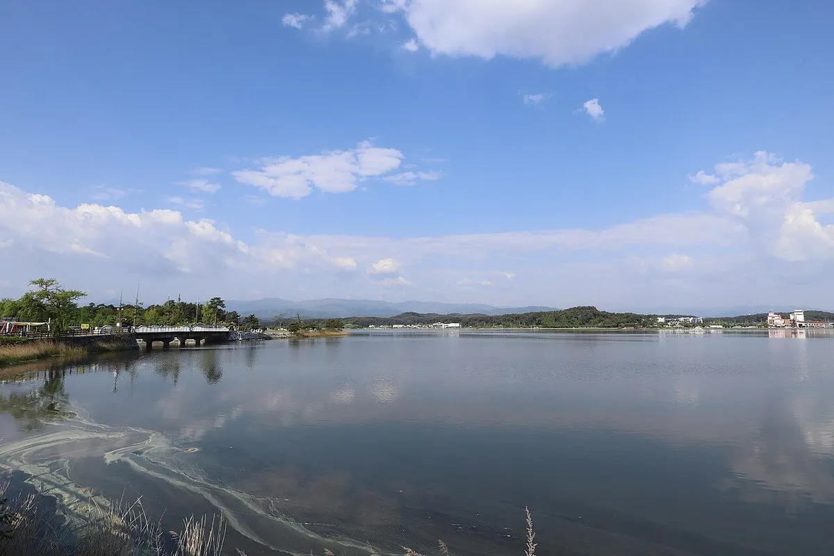The calm water of Gyeongpo Lake reflecting the sky and clouds.