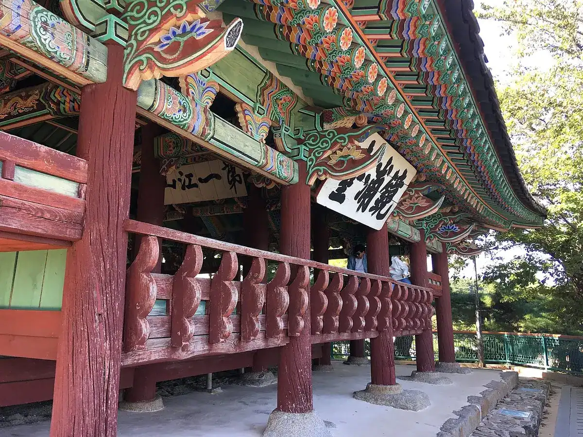The wooden Gyeongpodae Pavilion with its hipped-and-gabled roof on a rise among trees.