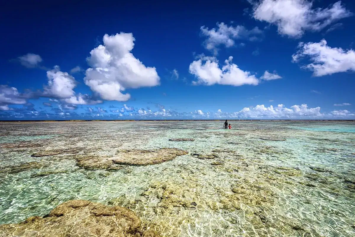 The shallow reef flat and clear water at Ritidian Point under puffy clouds