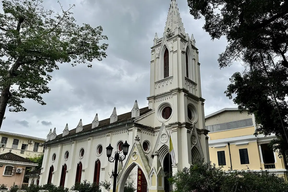 The white Our Lady of Lourdes Chapel on Shamian Island, framed by trees.
