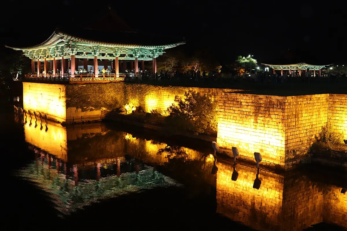 Illuminated Donggung Palace pavilions reflected in Wolji Pond at night.