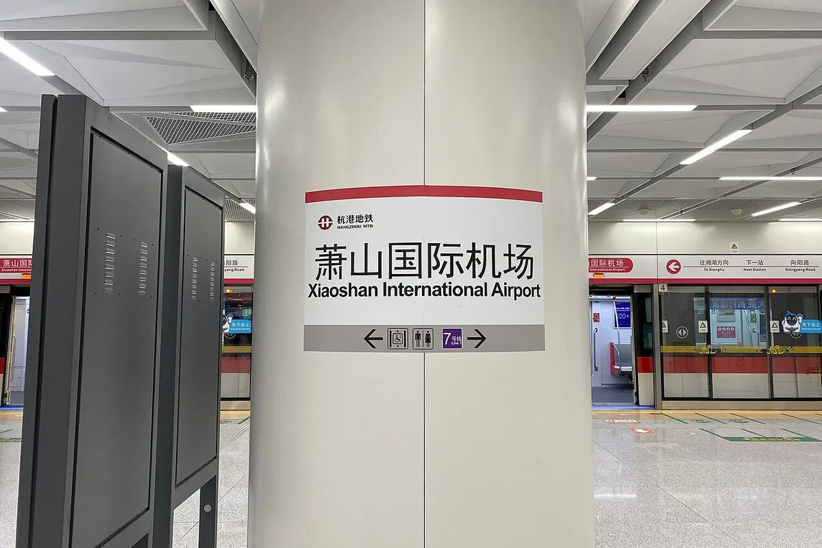 The station name sign on a platform pillar and the platform screen doors at Xiaoshan International Airport station.