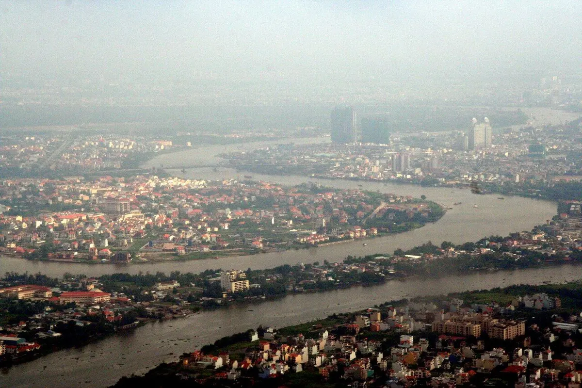 The Saigon River winding between red-roofed neighbourhoods, seen from the air.