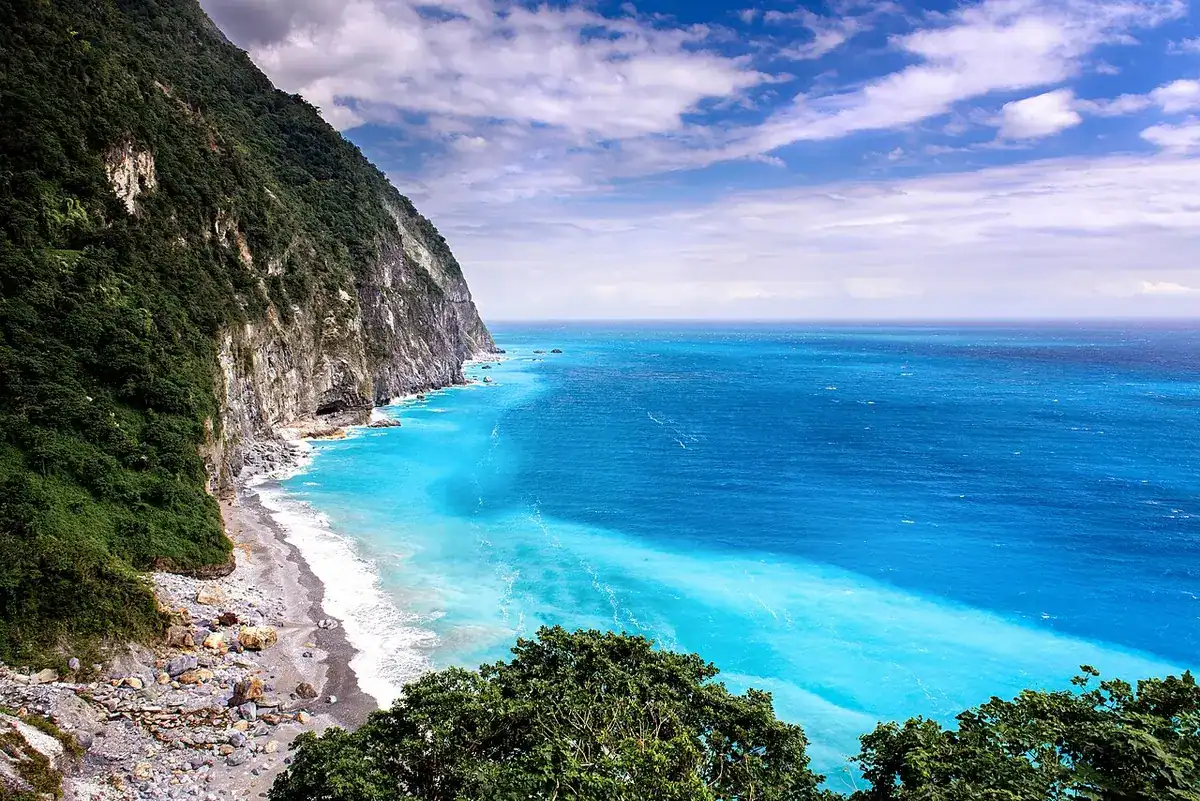 Steep mountain slopes dropping straight into the blue Pacific along the Qingshui Cliff coast