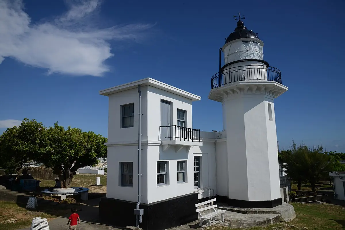 The white Kaohsiung Lighthouse on Cijin Island under a clear sky