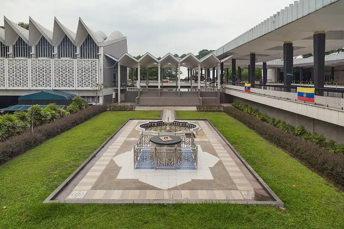 The courtyard pool of the National Mosque framed by its pleated-roof arcades