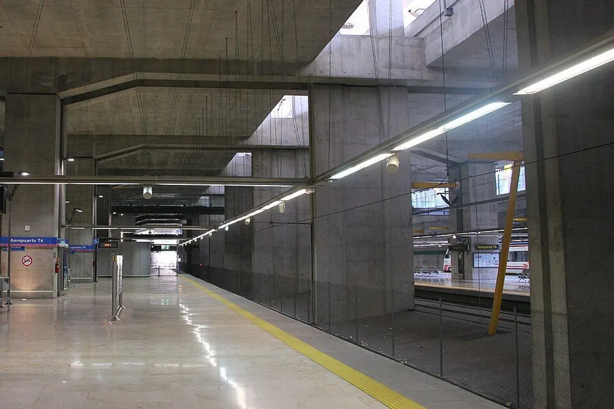 The Aeropuerto T4 platforms under bare concrete beams and skylights.