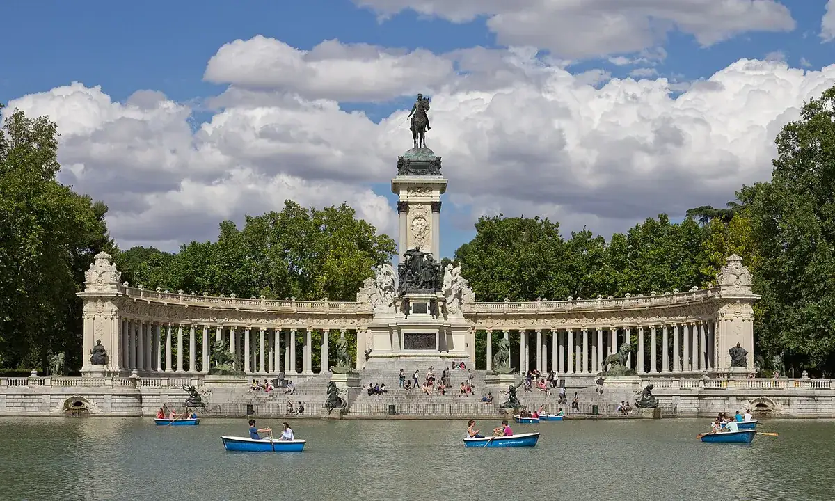 The Alfonso XII monument reflected in the Retiro pond, with rowing boats