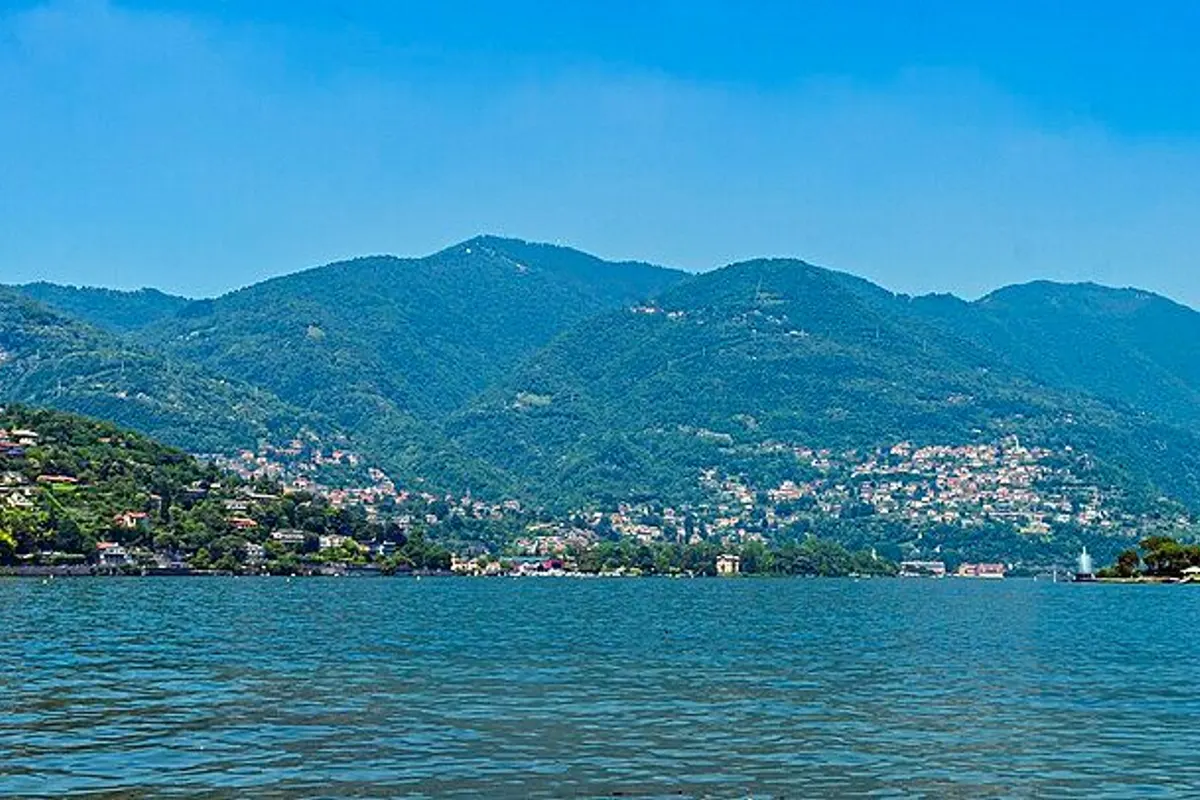 Lake Como seen from Como town, with green hills and lakeside villages on both shores.