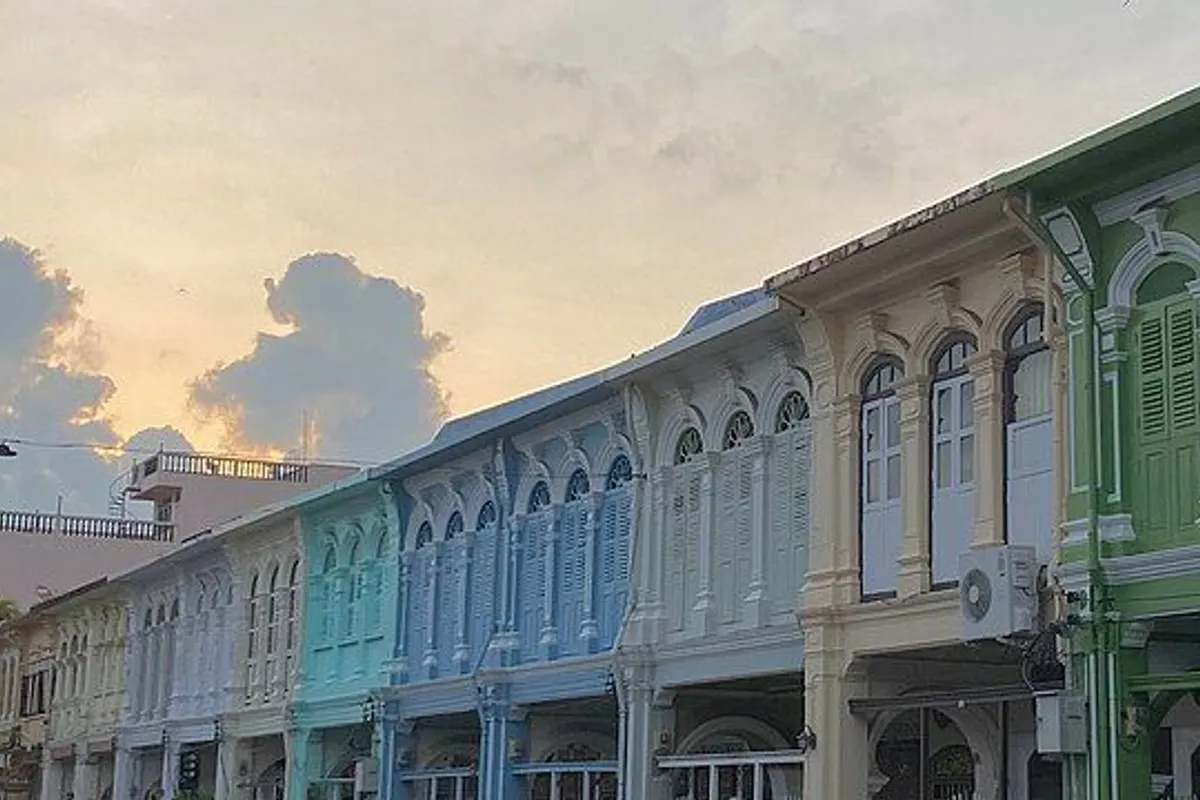 A row of pastel Sino-Portuguese shophouses under the morning sky.