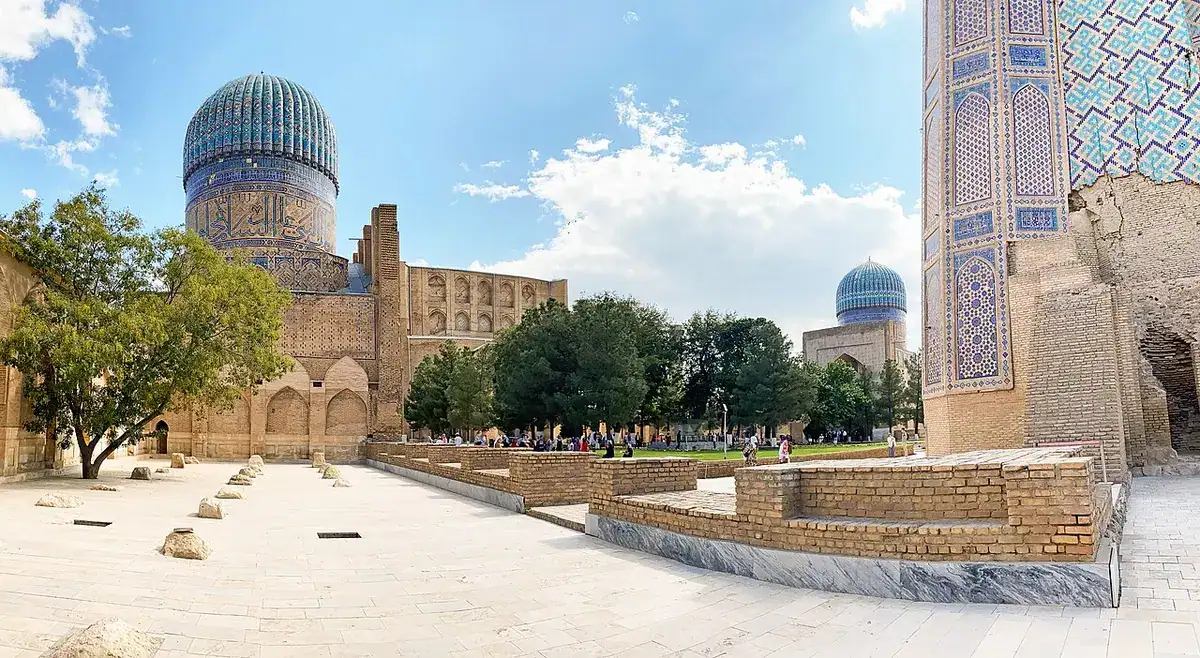 The courtyard of the Bibi-Khanym Mosque in Samarkand, with its huge portal and blue dome beyond.