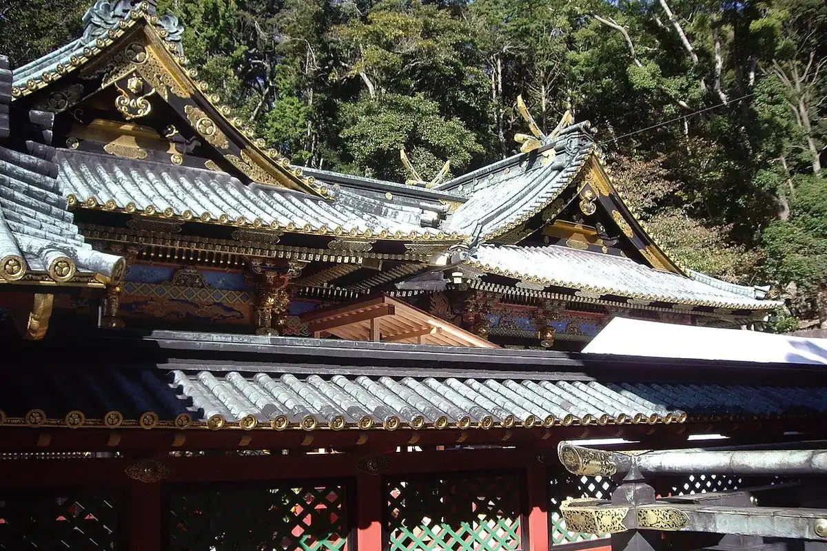 Gold-trimmed roofs and red lattice walls of the Kunozan Toshogu shrine buildings.