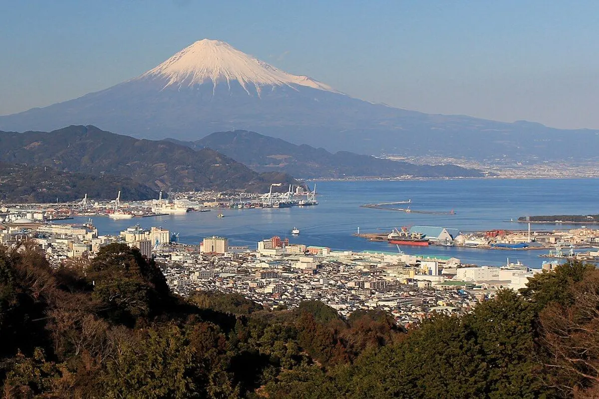 Snow-capped Mt Fuji rising beyond Shimizu Port and the city, seen from Nihondaira.