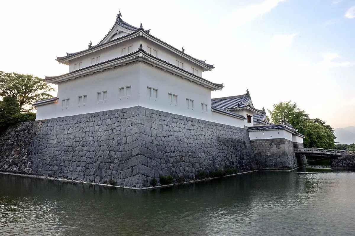 The white-walled Tatsumi-yagura turret and Higashi-gomon gate on stone walls above the moat.