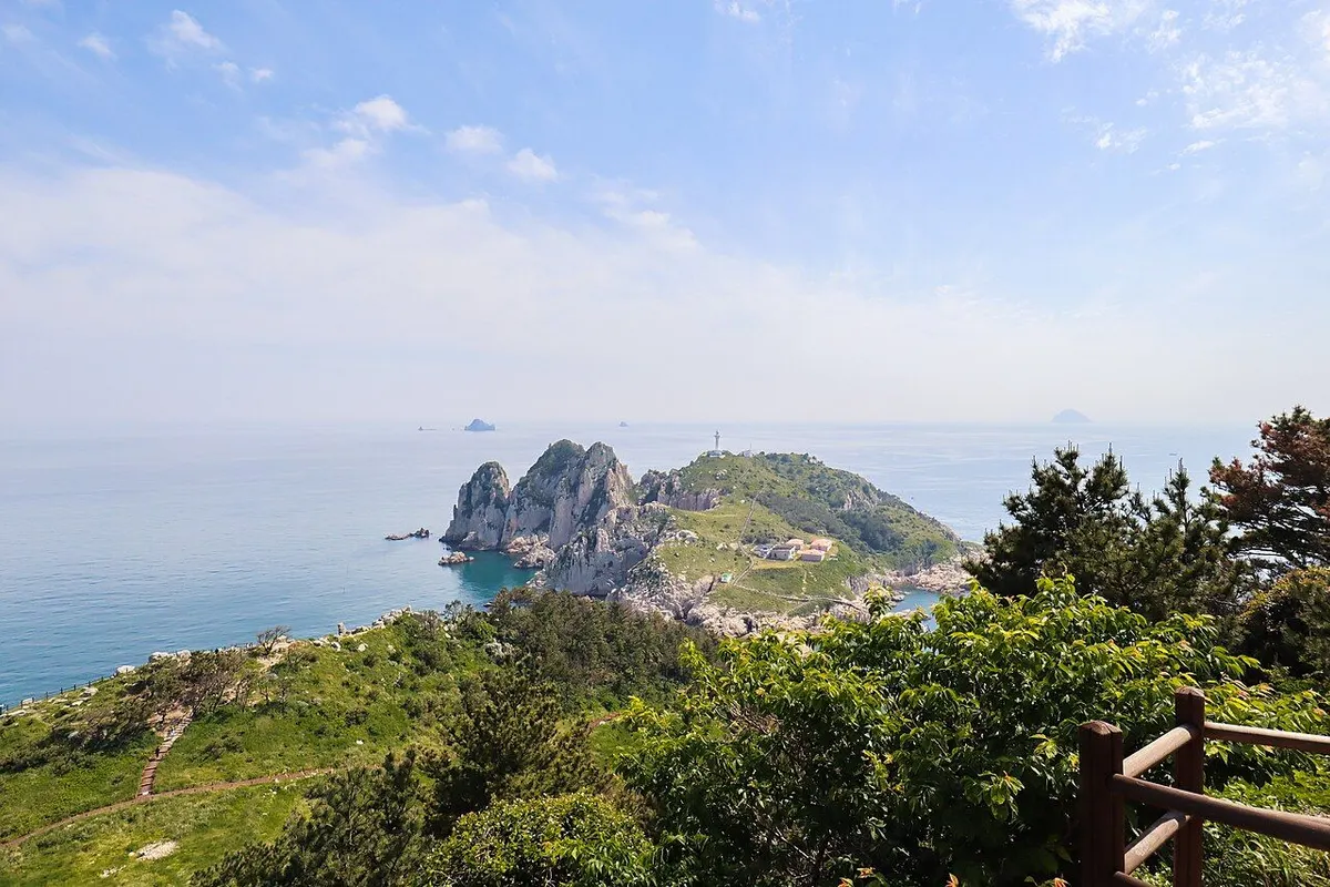 The rocky cliffs and white lighthouse of Deungdaeseom seen from Somaemuldo.