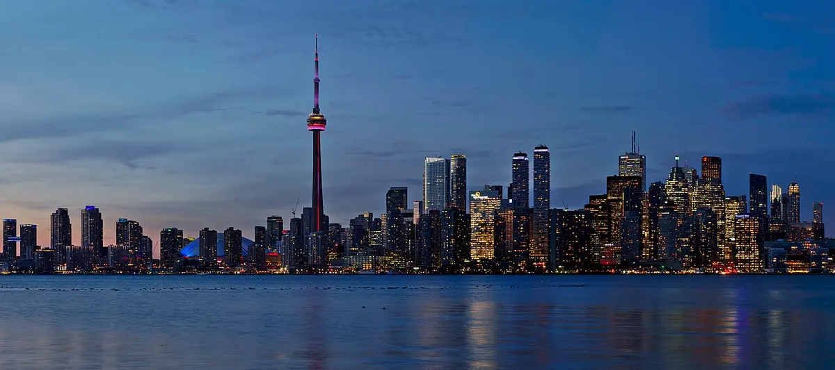 The CN Tower and downtown Toronto skyline across Lake Ontario at sunset