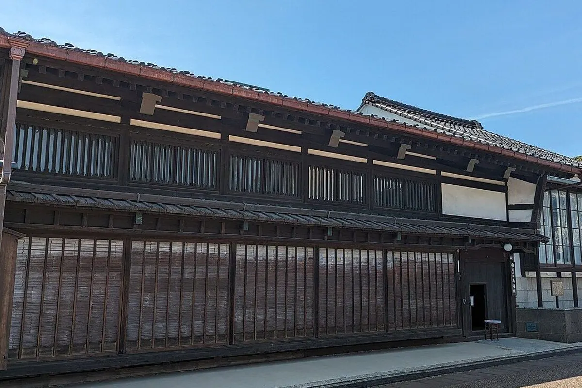 The long latticed wooden front of the former Baba merchant house under a clear sky.