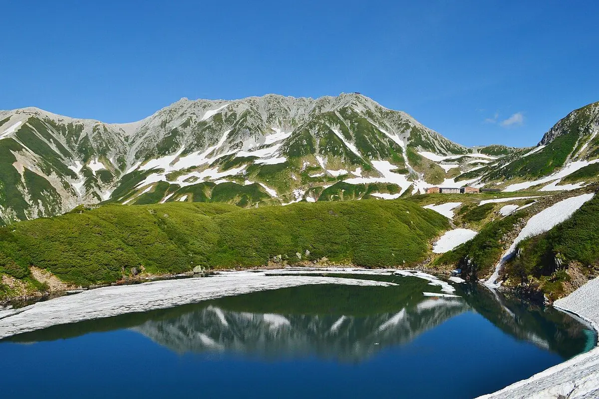 Mikurigaike Pond reflecting the Tateyama ridge with lingering snow.
