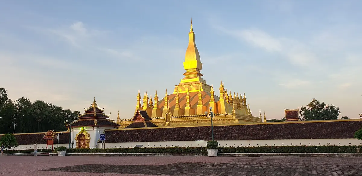 The golden great stupa of That Luang in Vientiane with the open grounds in front.