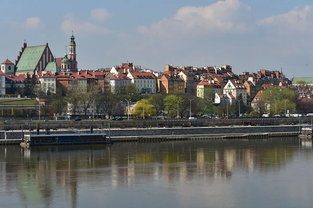 Green-roofed church towers and the colourful houses of the Old Town reflected in the Vistula River.