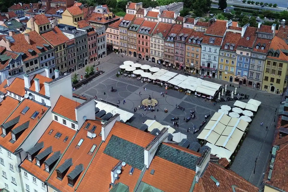 The Old Town Market Square seen from above, ringed by colourful houses with red roofs.