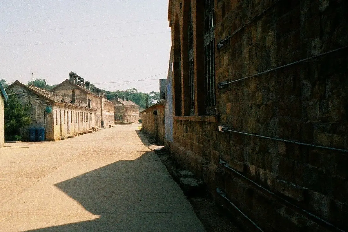 Old stone naval buildings lining a quiet lane on Liugong Island.