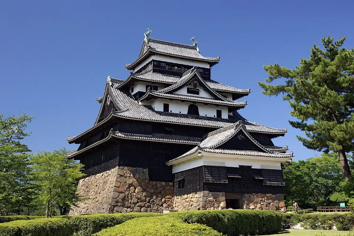 Matsue Castle's keep with black-boarded walls and layered roofs on a stone base.