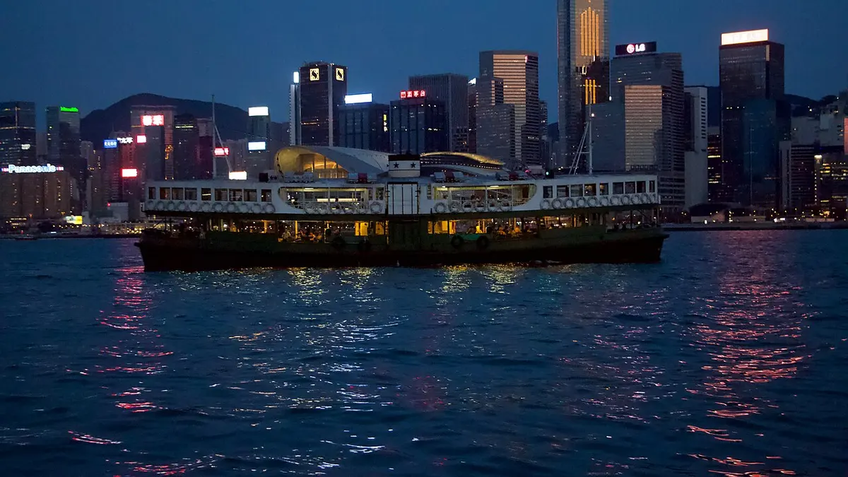 A Star Ferry crossing Victoria Harbour at night.