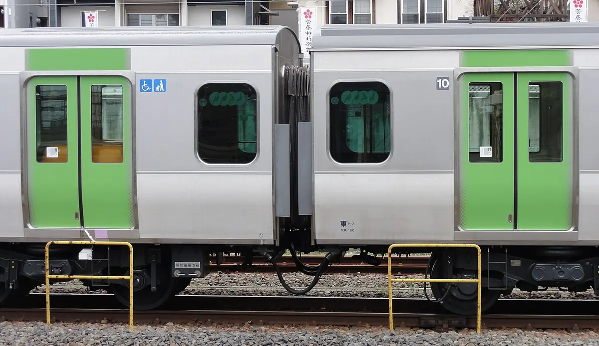A JR Yamanote Line E235 series train with its green stripe in Tokyo.