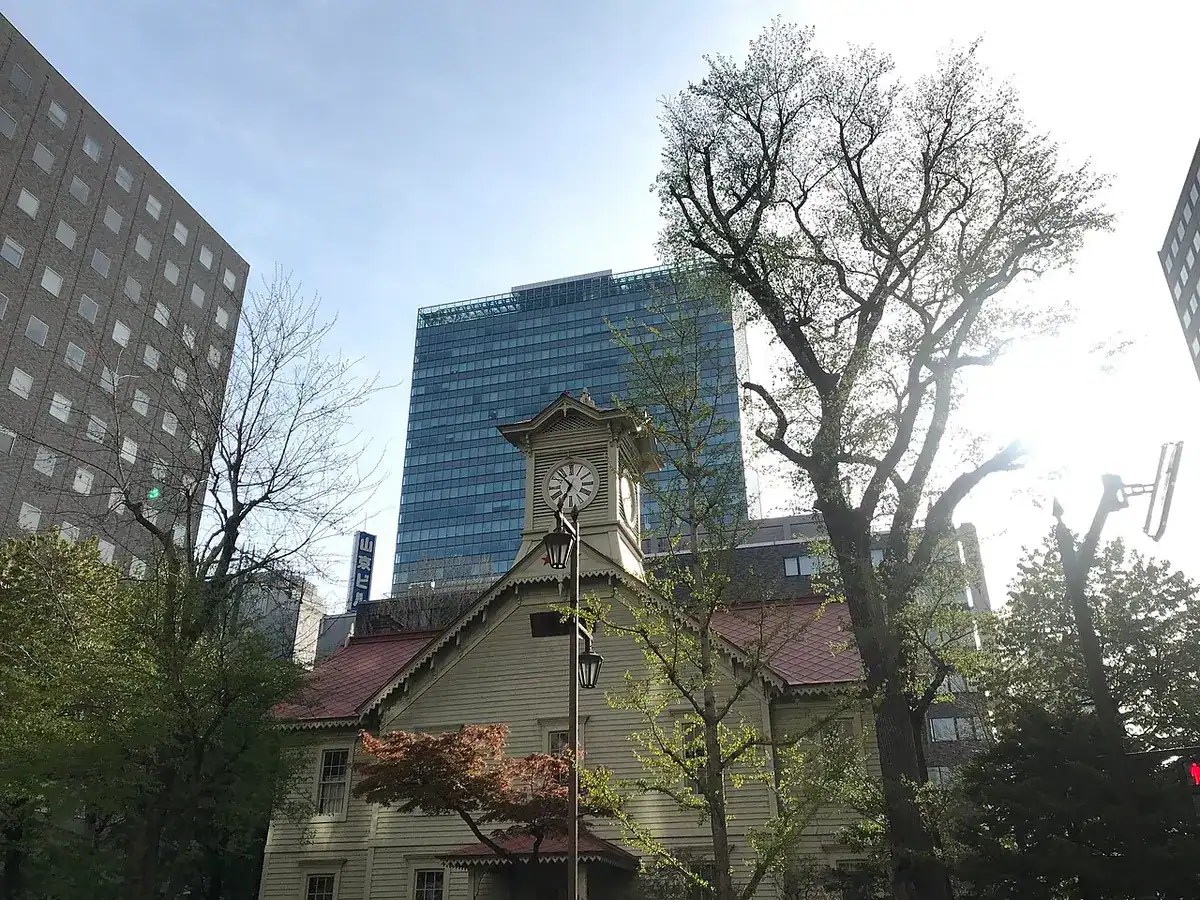 The white wooden Sapporo Clock Tower with its clock on top.