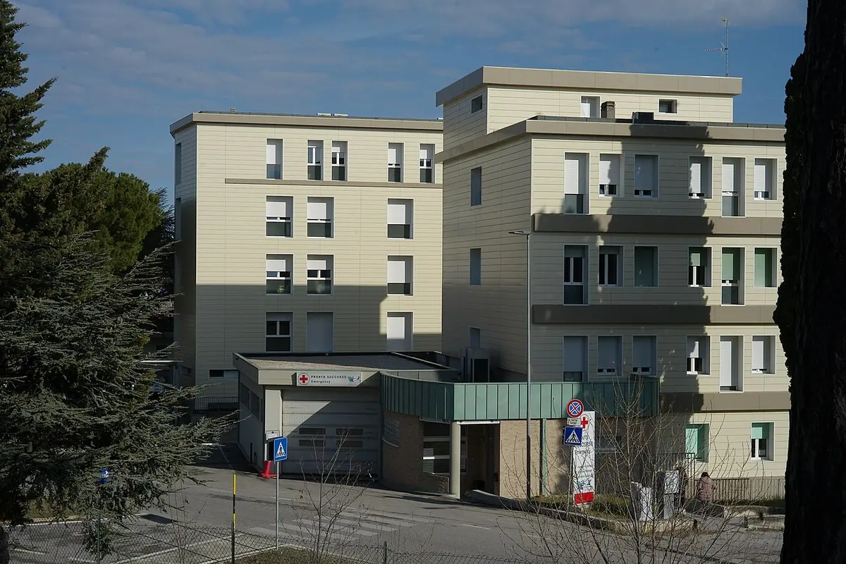 The entrance to a hospital emergency department, marked with a 'Pronto Soccorso' (emergency) sign.