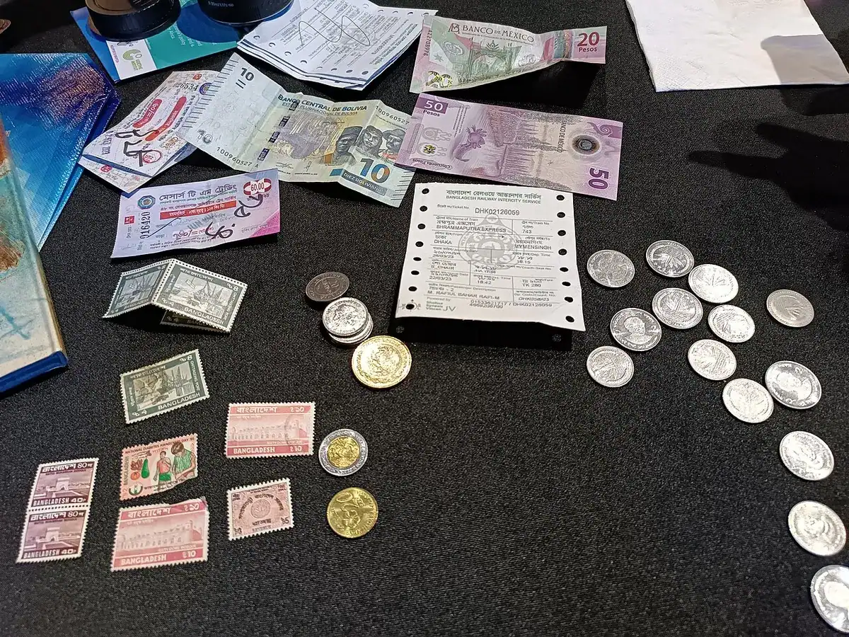 Coins and banknotes from several countries spread out together on a table.