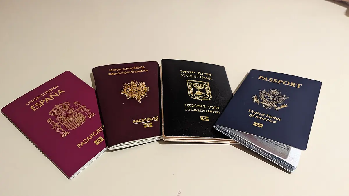 Four closed passports from different countries lying side by side.