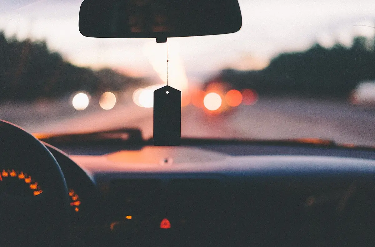 A highway stretching ahead beyond the dashboard, seen from the driver's seat.